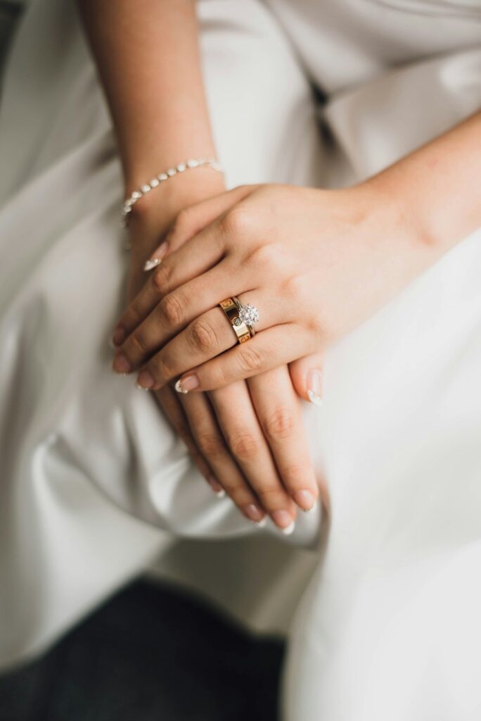 Brides hands resting in her lap with her engagement ring in focus