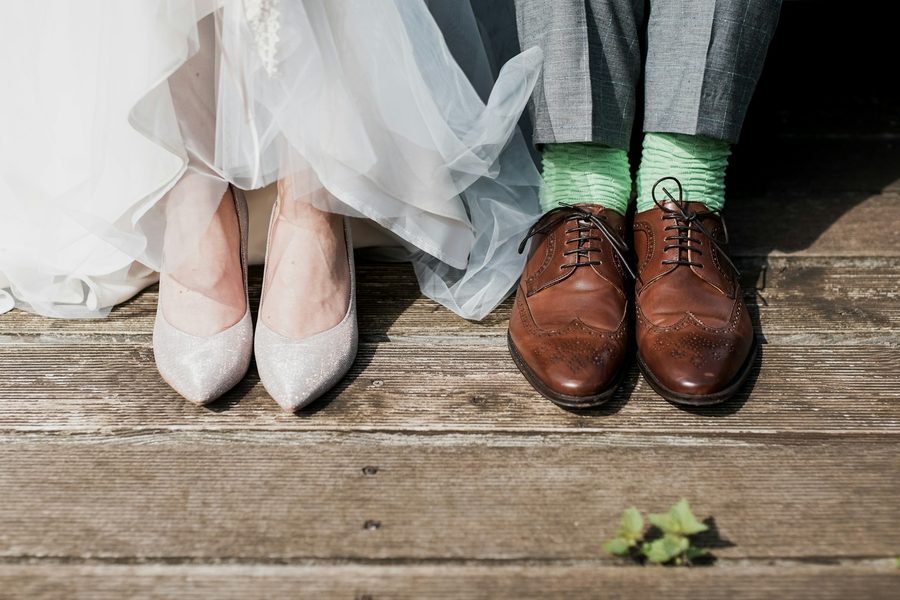 Brides heels and grooms brogues side by side on decking